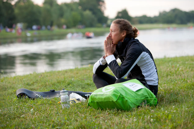 Triathlete Chrissie Wellington sitting on the grass reflecting before a race