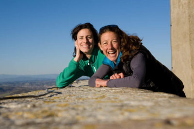 Rebecca Marshall and Chrissie Wellington lean on a wall and smile at the camera