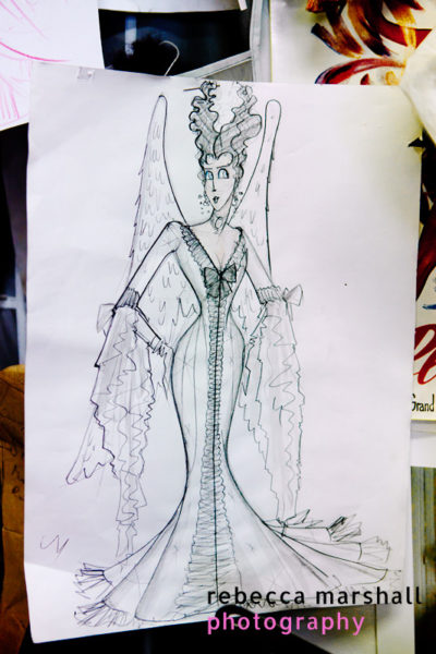 Sketch of an extravagantly dressed woman with wings on the wall at 'Aux Corsets de Montmartre'