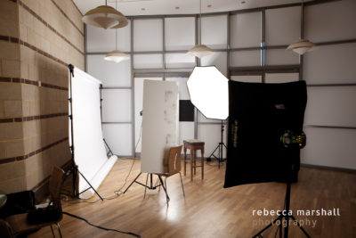 Photograph of lighting set-up for portrait photography with white backdrop in a meeting room