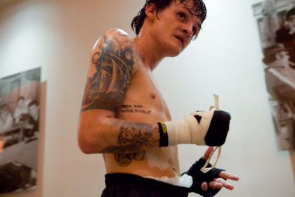 Boxer Hekkie Budler, shirtless, taking off his hand wraps after training