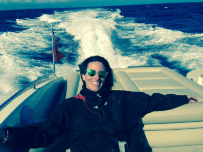 Photograph of photographer Rebecca Marshall sitting on the back of a power boat