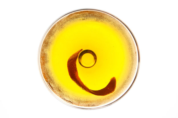 Close-up photograph taken from overhead of a yellow glass of whisky