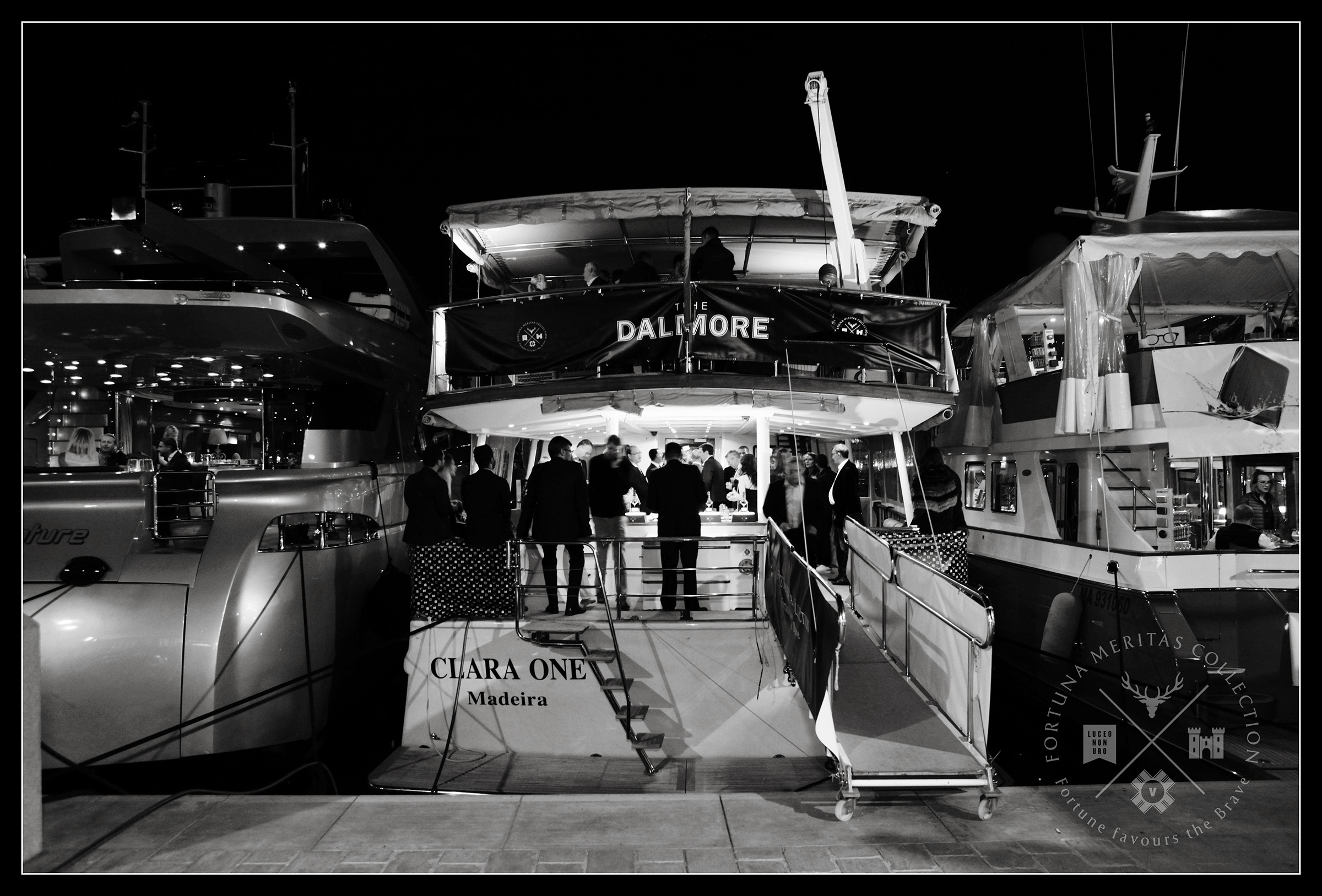 Wide view of yacht at night-time hosting a cocktail party 
