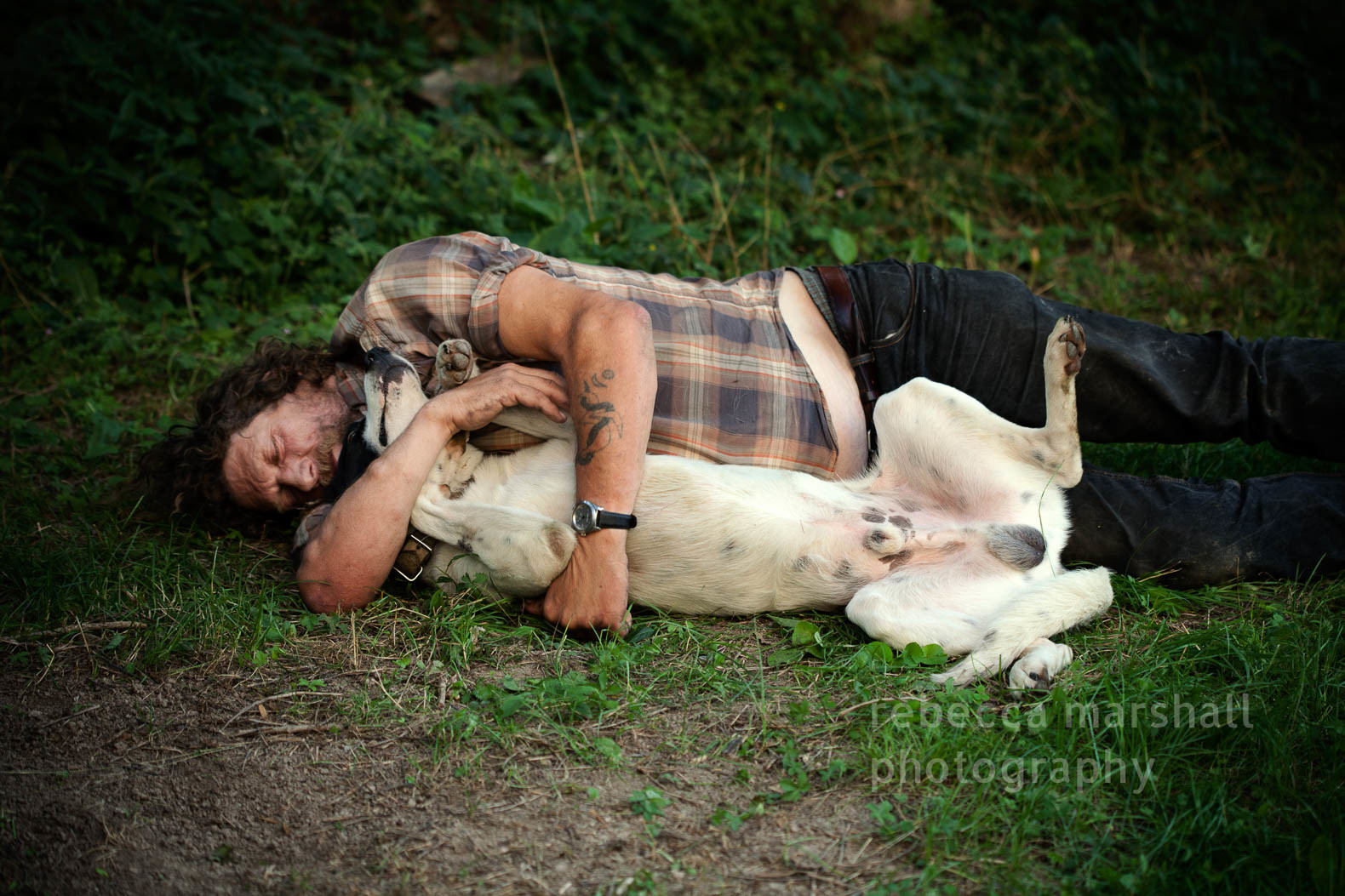 A shepherd sleeps with his sheepdog in his arms