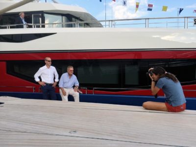 Photo of photographer at work onboard a yacht taking a portrait of 2 men