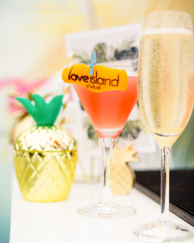 Detail photograph of cocktail and champagne glass showing sign 'Love Island'