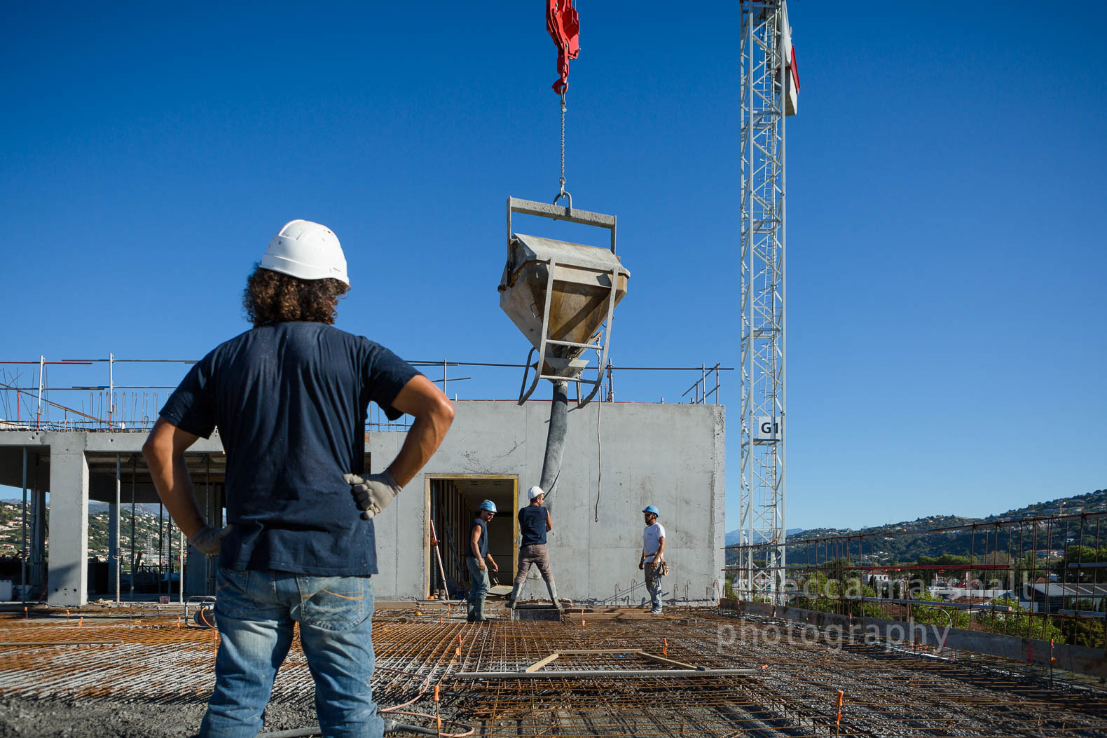 Photograph of construction workers on the rooftop of a building site