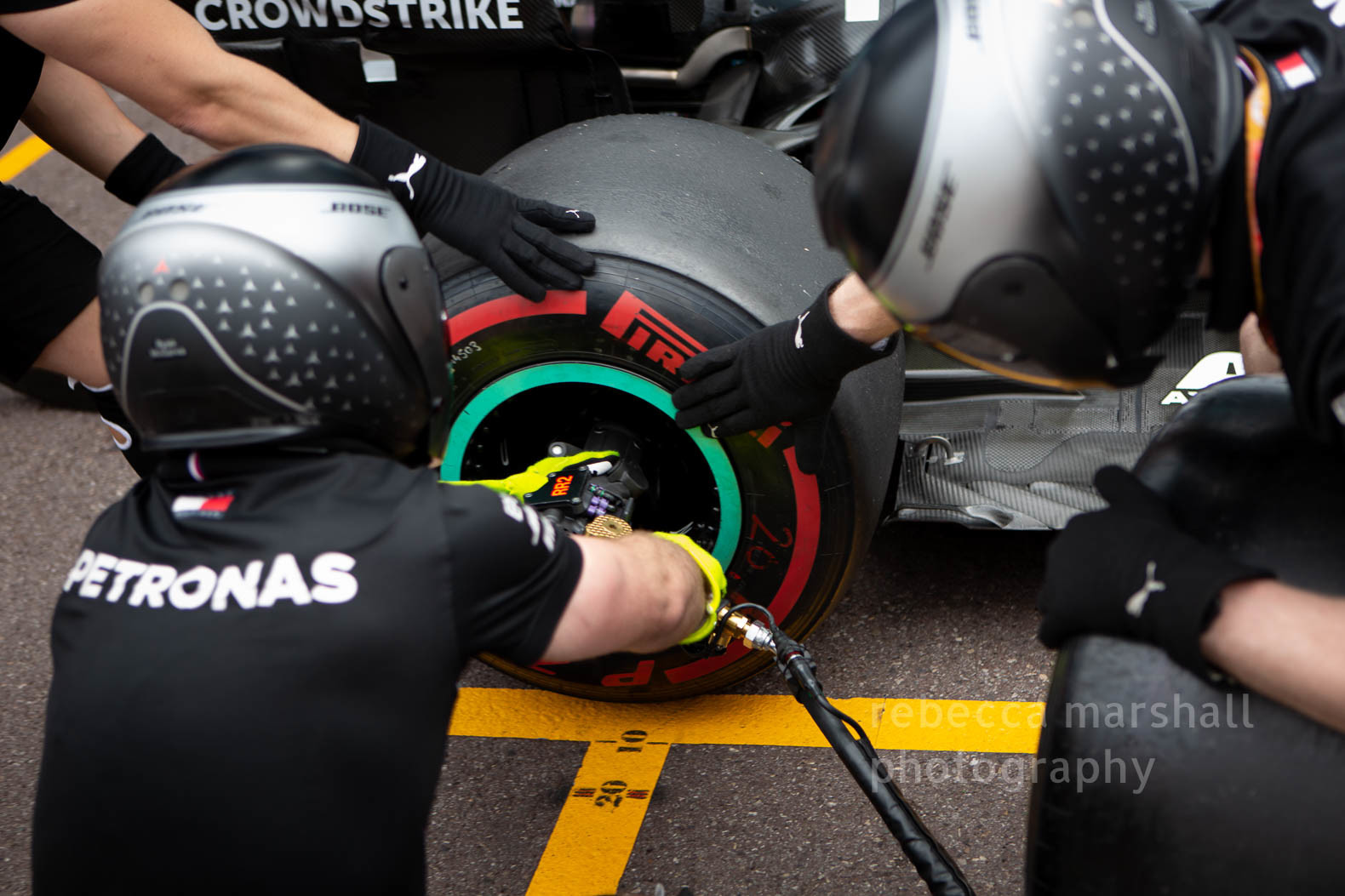 Close-up photograph of Formula One team changing a tyre