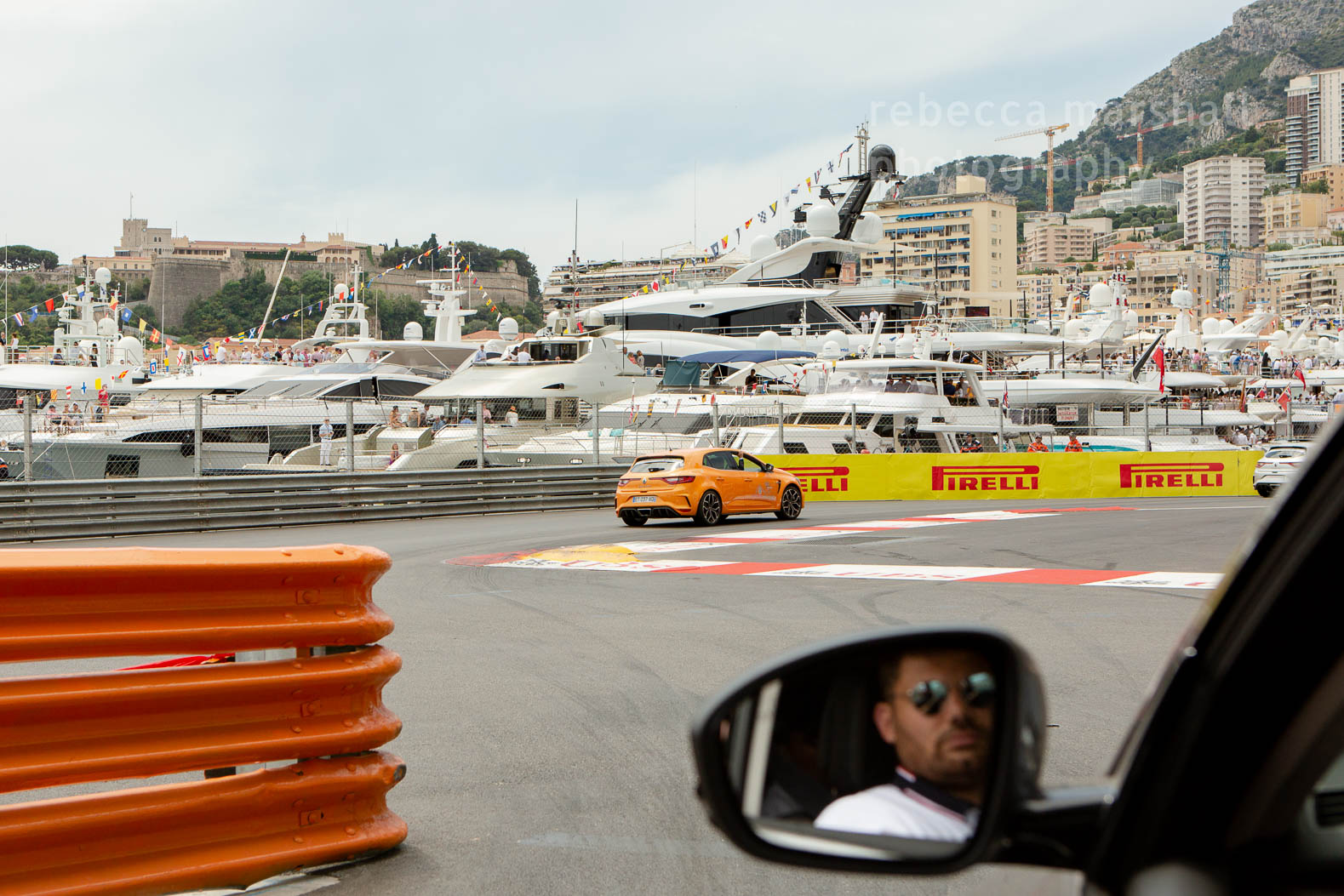 Photograph taken from inside a car driving round the race track of the Monaco Grand Pris showing harbour in background
