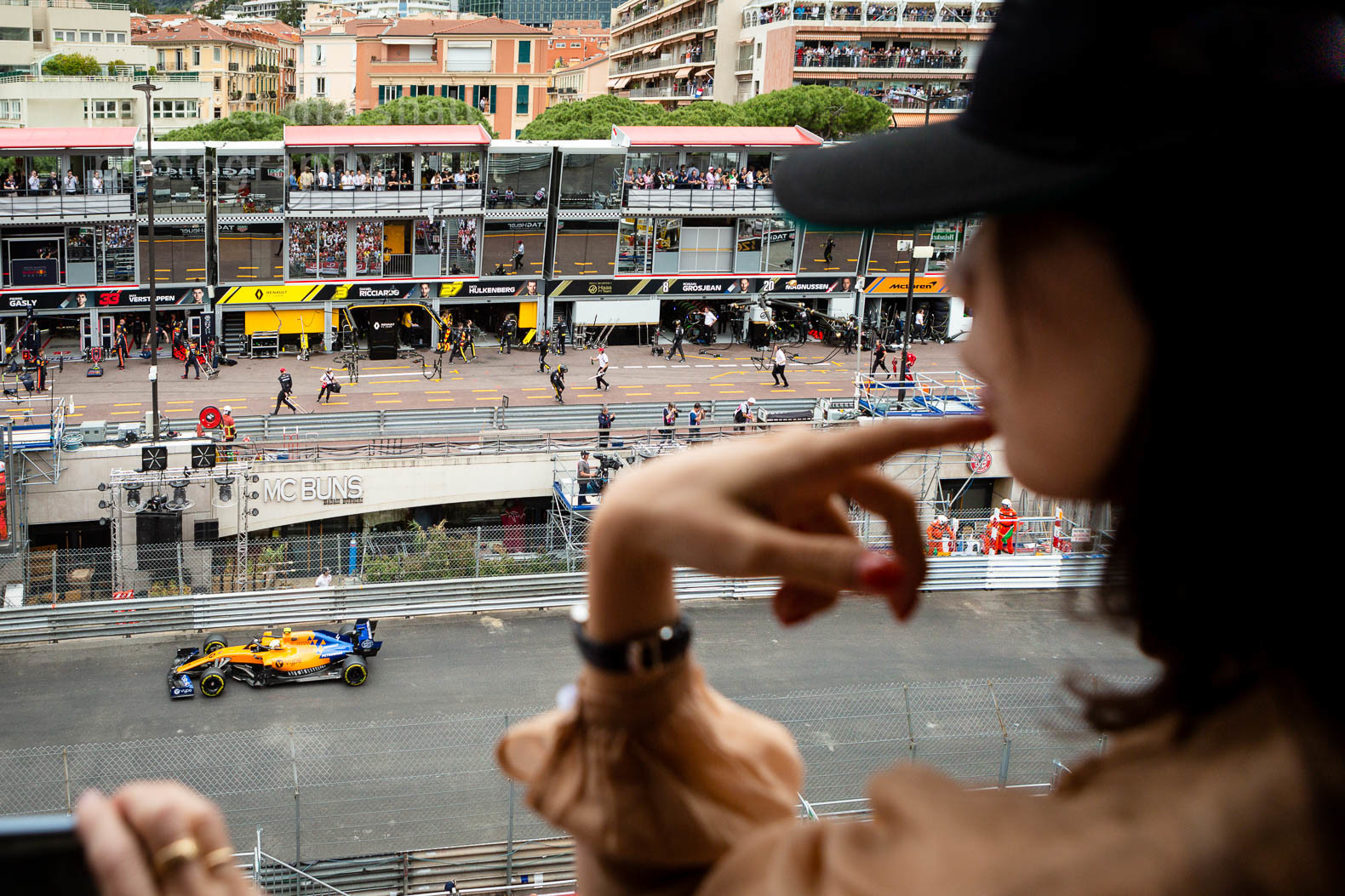 Unidentifiable woman in profile watching the Monaco Grand Prix from a high viewpoint