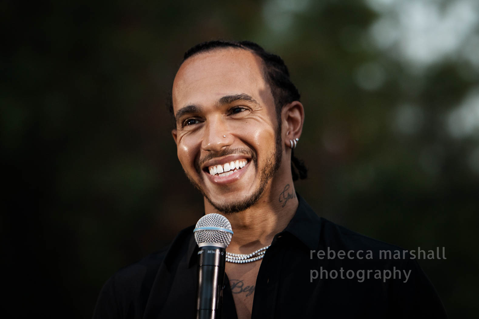 Photograph of Lewis Hamilton speaking into a microphone