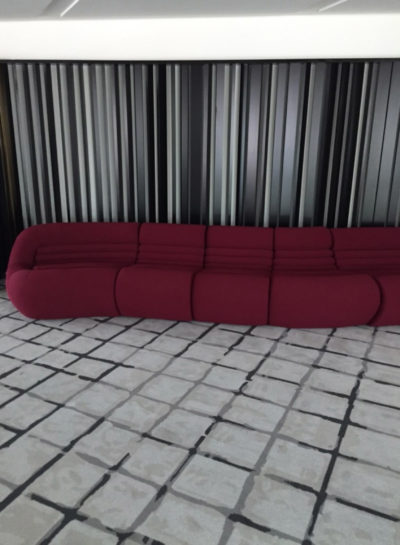 Snapshot of red couch on grey carpet in empty room