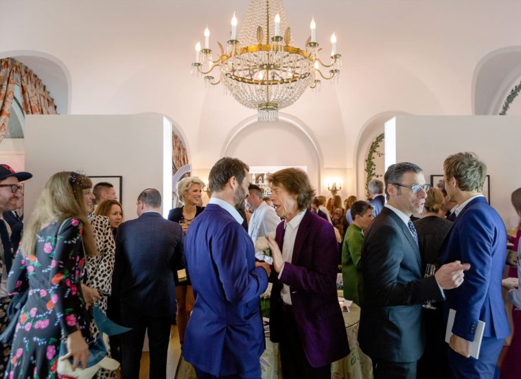 Wide photograph of people mingling in a party setting