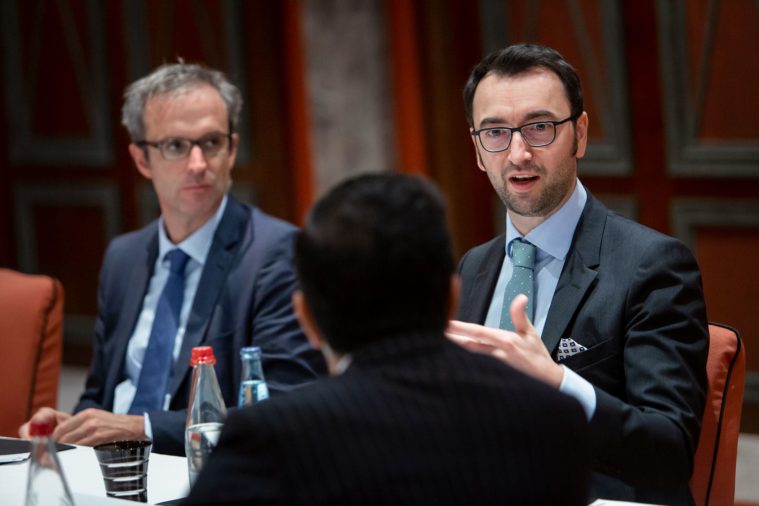 3 men in suits talking in a business meeting