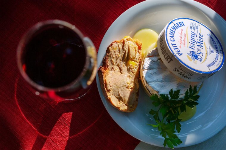 Overhead photograph of a glass of wine and plate of cheese and foie gras