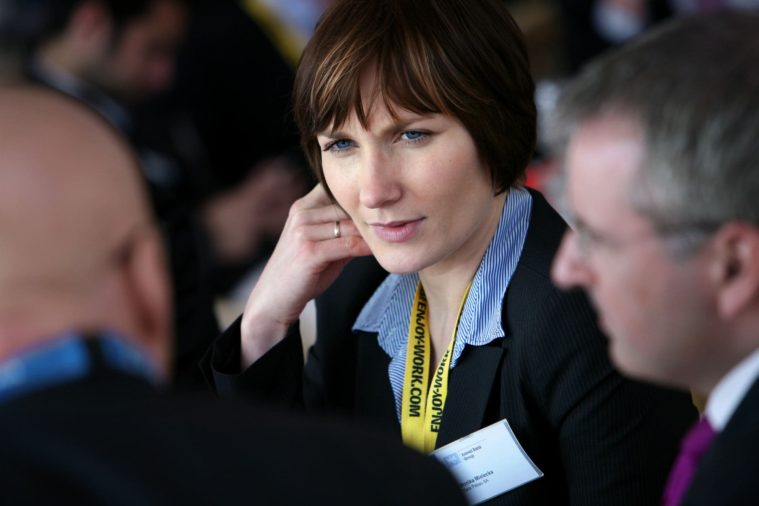 Close-up photograph of a businesswoman listening to colleagues