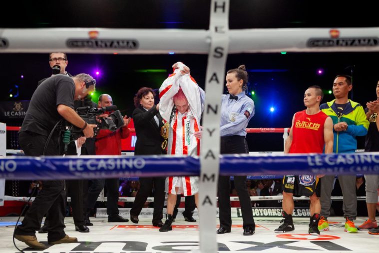 Winning boxers arms are raised by the referee in the ring