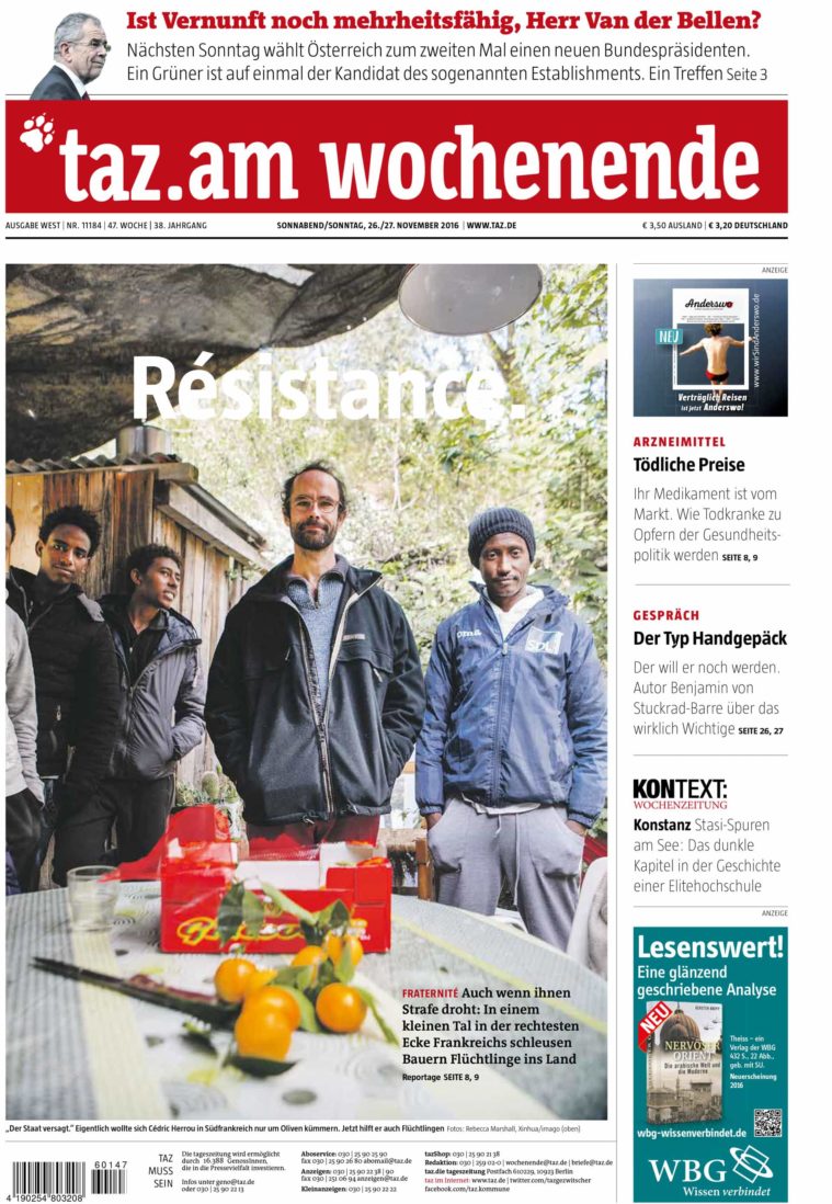 Newspaper cover showing a photograph of 4 men standing behind a table with oranges on it