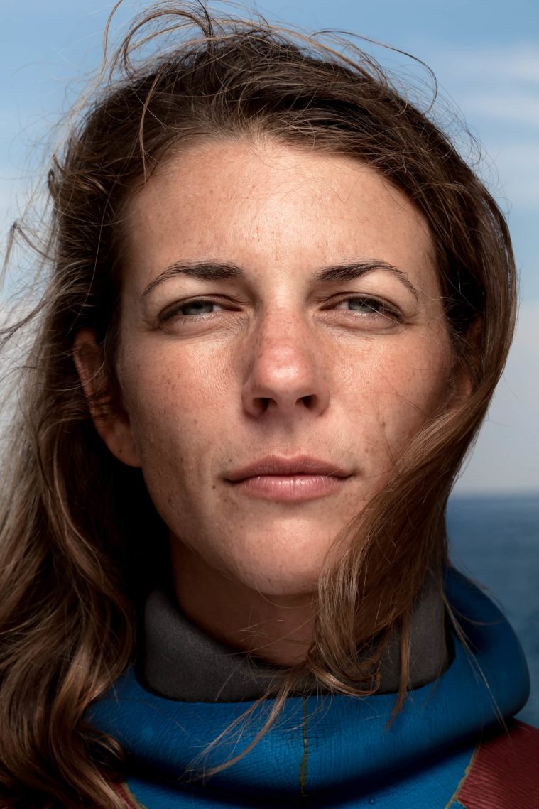 Close-up portrait of woman in a wetsuit with the sea in the background