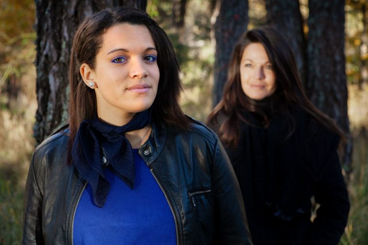 2 women pose for a portrait in the forest