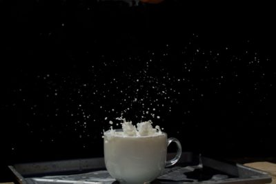 Action photo of milk splashing from a white cup