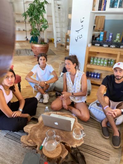 Photograph of a group of 4 people sitting on the floor around a computer