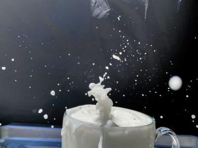 Action photo of milk splashing from a white cup