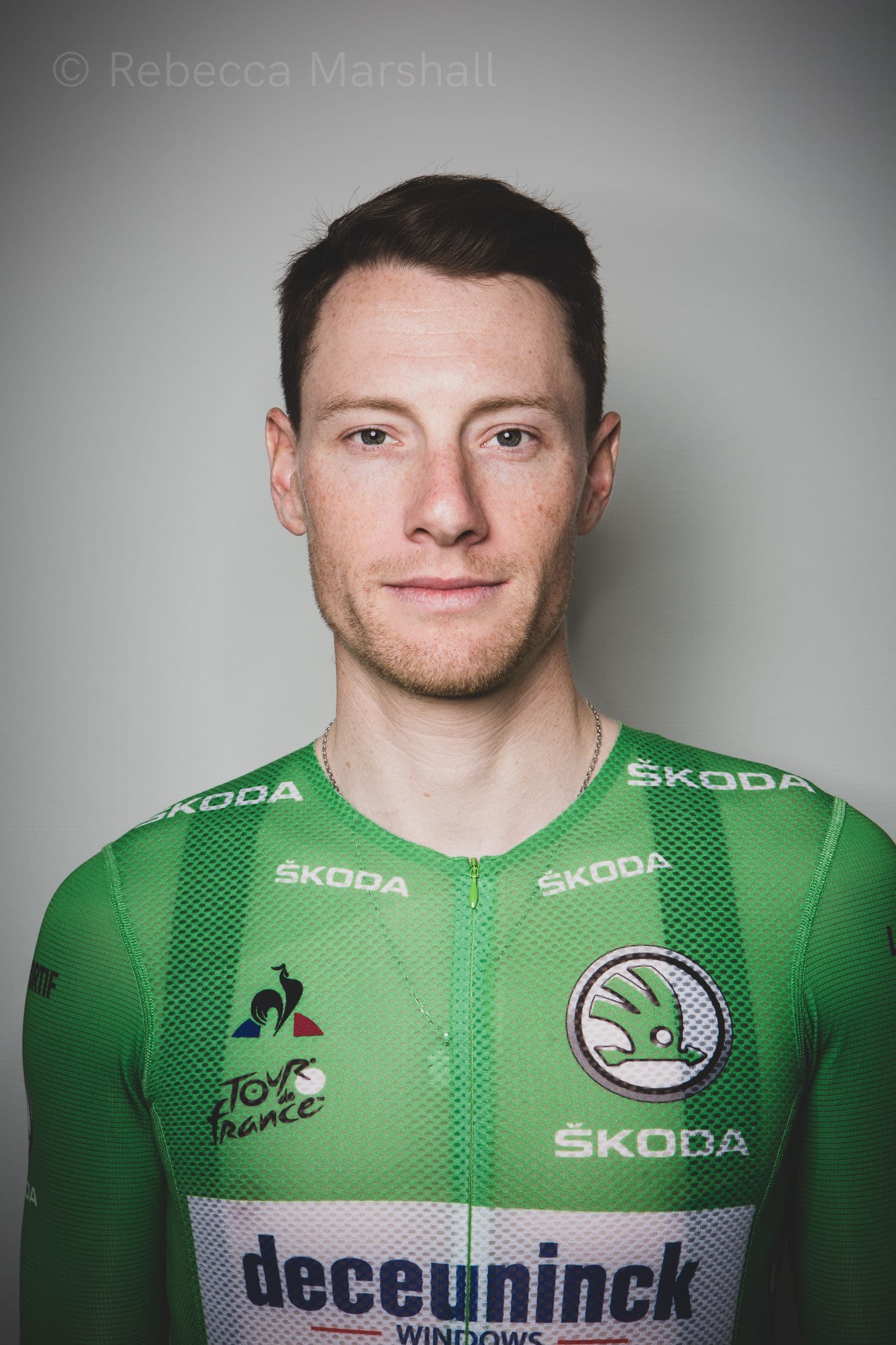 Close-up studio portrait of Sam Bennett, professional road racing cyclist, in a green jersey