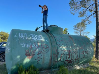 Woman with camera stands on top of water tank