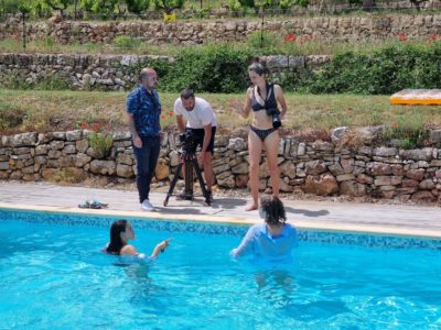Photography team beside models in an outdoor pool