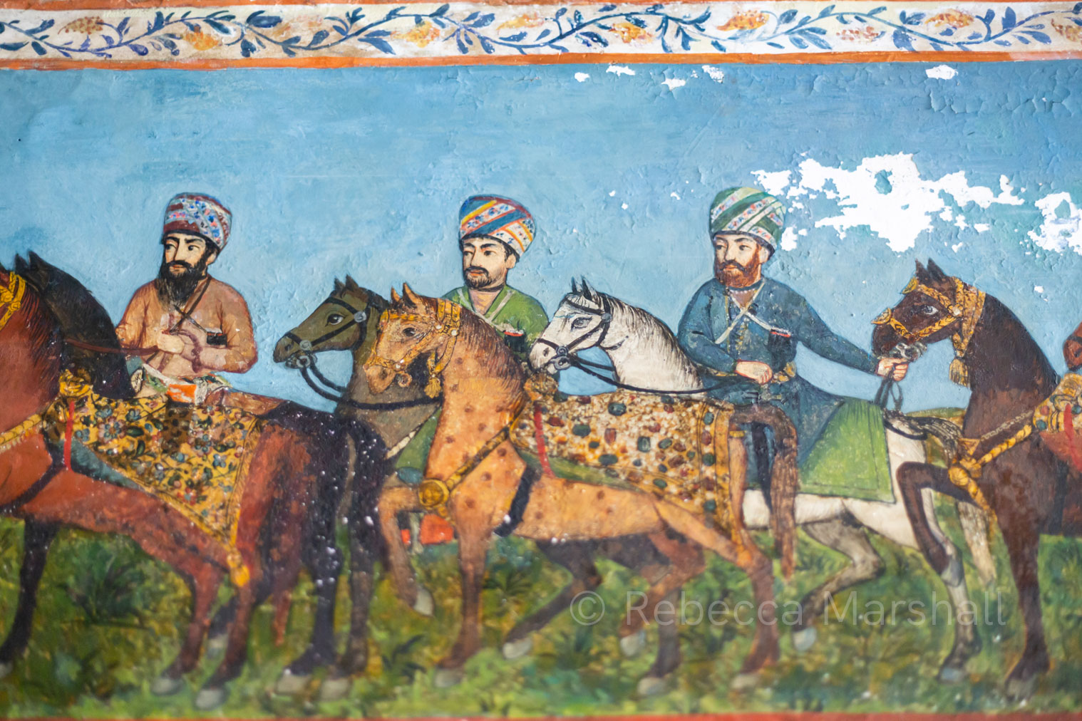 A close up photograph of an 18th-century colour fresco, showing horses and their male riders