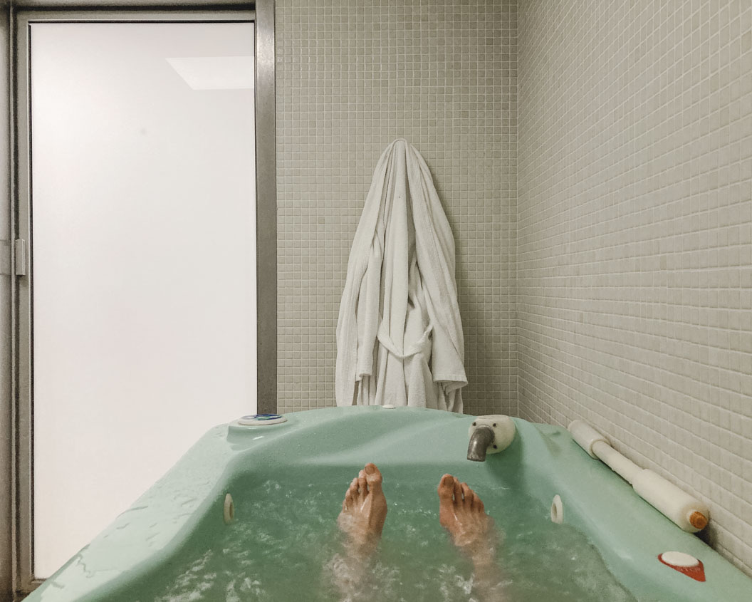 Photograph of feet in a turquoise bathtub